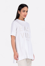 Model wearing white long T-shirt, close-up view – East Vibe